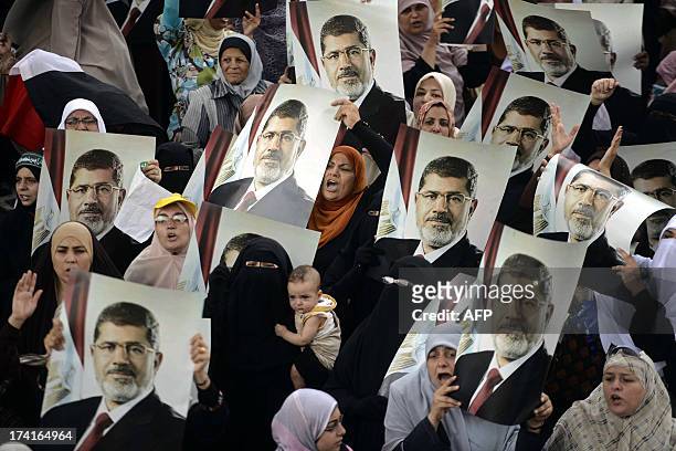 Female Egyptian supporters of the Muslim Brotherhood hold up portraits of Egypt's ousted president Mohamed Morsi during a rally in Cairo on July 21,...