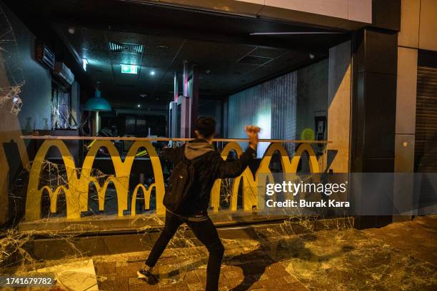 Protester vandalizes a McDonald's restaurant during a demonstration of an explosion at a hospital in Gaza killed hundreds on October 17, 2023 in...