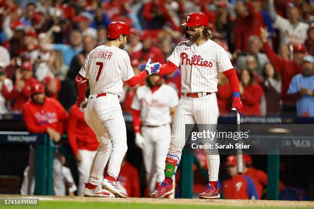 Trea Turner of the Philadelphia Phillies celebrates with Bryce Harper after his first inning solo home run against the Arizona Diamondbacks during...