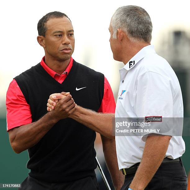 Golfer Tiger Woods shake hands with his former caddie Steve Williams, current caddie of Australia's Adam Scott, at the end of their round during the...