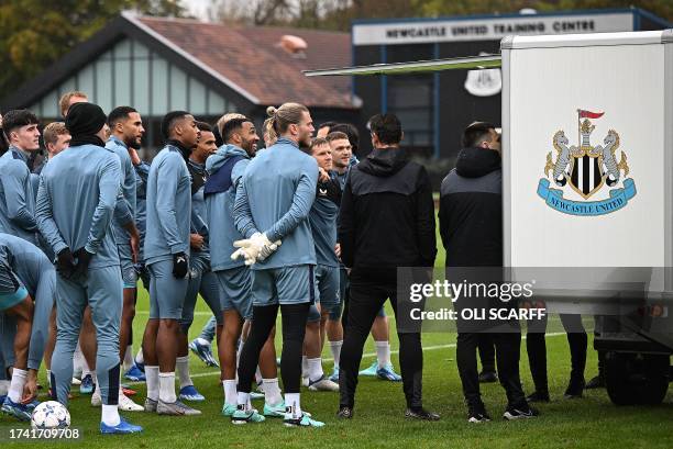 Newcastle United's English striker Callum Wilson reacts with teammates as they attend a training session at the team's training facility in...