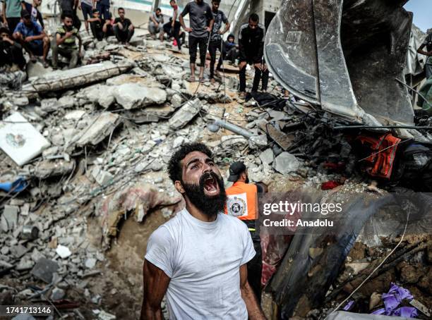 Palestinian man mourns as civil defense teams and residents conduct a search and rescue operation for Palestinians stuck under the debris of a...