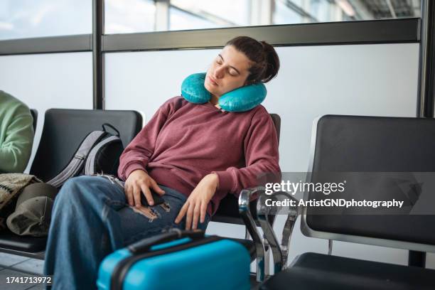 young woman napping while waiting for the flight. - neck pillow stock pictures, royalty-free photos & images
