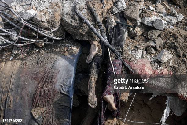 Dead bodies stuck in rubble are seen as civil defense teams and residents conduct a search and rescue operation for Palestinians stuck under the...