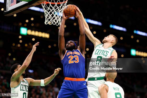 Kristaps Porzingis of the Boston Celtics blocks a shot from Mitchell Robinson of the New York Knicks during the second quarter of the preseason game...