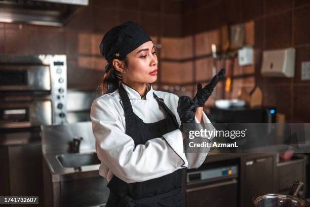 mains protégées : un chef asiatique se prépare à cuisiner - paire de gants noirs photos et images de collection
