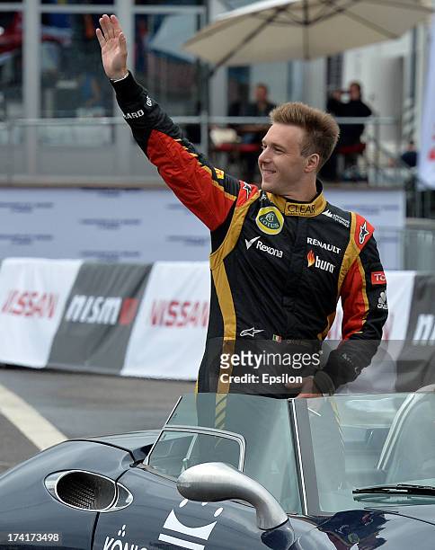 Italian Formula One driver Davide Valsecchi of Lotus gestures in front of the Moscow's Kremlin during the Moscow City Racing show on July 21, 2013 in...