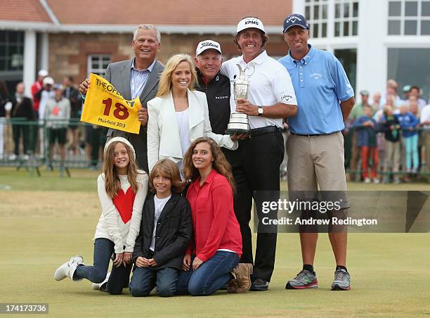 Phil Mickelson of the United States holds the Claret Jug wife Amy and children Evan, Amanda and Sophia, manager Steve Loy, coach Butch Harmon and...