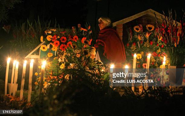 Woman prays in front of a grave of a relative at the cemetery of San Gregorio Atlapulco, in Mexico City, 02 November 2006, during the Day of the Dead...