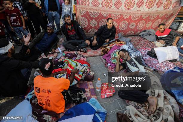 Injured Palestinians and their families take shelter in a school of the United Nations Relief and Works Agency for Palestine Refugees in the Near...