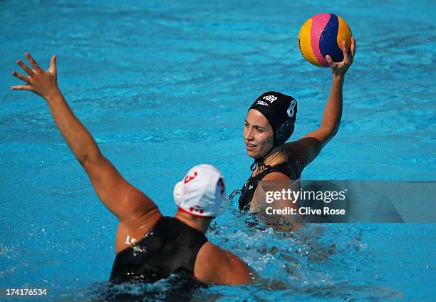 Hazel Musgrove of Great Britain passes a ball under pressure from Katrina Monton of Canada during the Women's Water Polo first preliminary round...