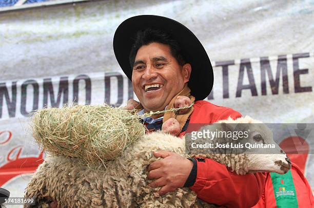 Villager holds a lamb during the III Festival Intercultural de Música y Danzas Autóctonas, organized by the Government in La Paz on July 20, 2013 in...