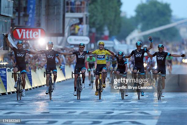 Winner of the 2013 Tour de France, Chris Froome of Great Britain and SKY Procycling celebrates with teammates as they cross the finish line together...