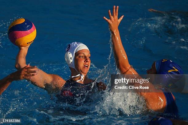 Tóth Ildikó of Hungary passes the ball under pressure from Melani Dias of Brazil compete in the Women's Water Polo first preliminary round match...