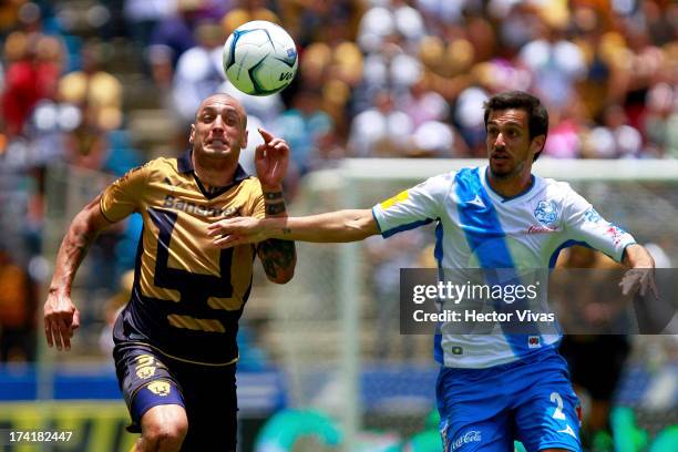 Ariel Nahuelpan of Pumas struggles for the ball with Jonathan Lacerda of Puebla during a match between Pumas and Puebla as part of the Torneo...