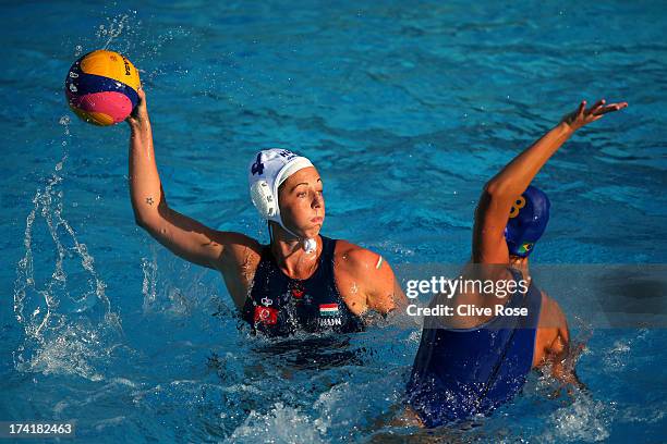 Dora Agnes Kisteleki of Hungary looks to pass the ball under pressure from Izabella Chiappini of Brazil in the Women's Water Polo first preliminary...