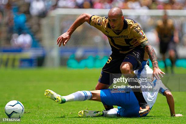 Ariel Nahuelpan of Pumas struggles for the ball with Jonathan Lacerda of Puebla during a match between Pumas and Puebla as part of the Torneo...