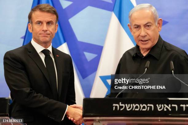 Israeli Prime Minister Benjamin Netanyahu shakes hands with French President Emmanuel Macron after their joint press conference in Jerusalem on...