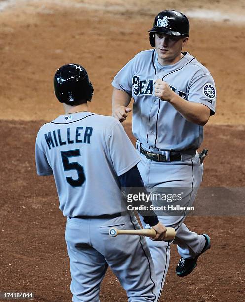 Kyle Seager and Brad Miller of the Seattle Mariners celebrate after Seager scored a run in the fifth inning against the Houston Astros at Minute Maid...