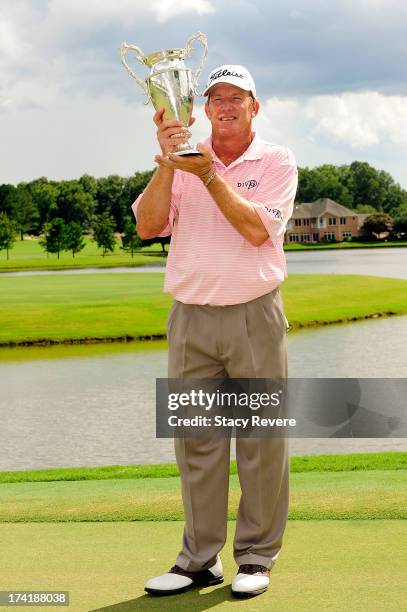 Woody Austin poses with the winners trophy following the final round of the Sanderson Farms Championship at Annandale Golf Club on July 21, 2013 in...