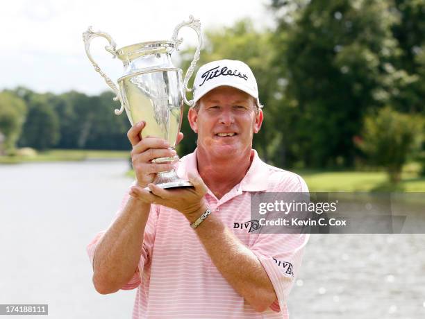 Woody Austin poses with the trophy after winning in a playoff on the 18th hole during the final round of the Sanderson Farms Championship at...