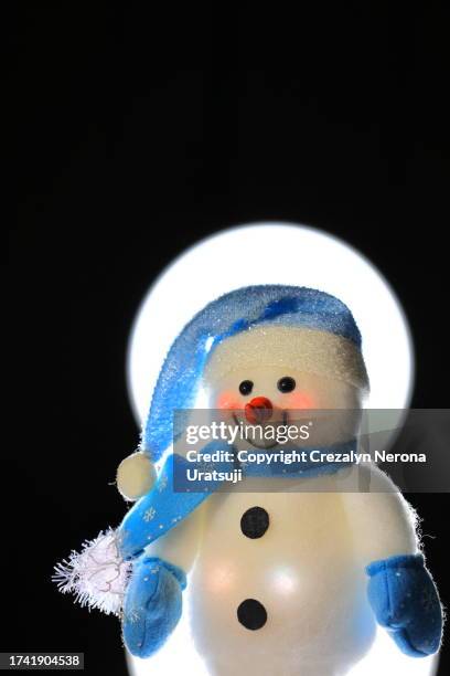 snowman with santa claus hat,hand warmer gloves and neck gaiter (1) in black background plus white led light - buff stock pictures, royalty-free photos & images