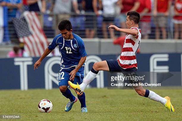 Jose Torres of the United States battles for the ball against Andres Flores of El Salvador during the 2013 CONCACAF Gold Cup quarterfinal game at M&T...
