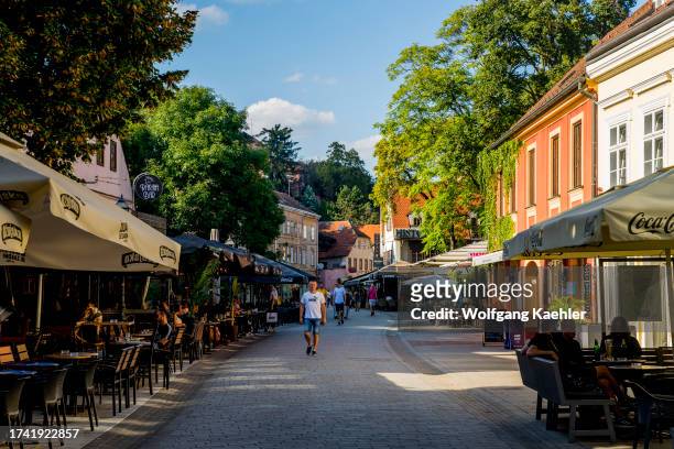 Street scene with people in a sidewalk cafe/restaurant in the old town of Zagreb, Croatia.