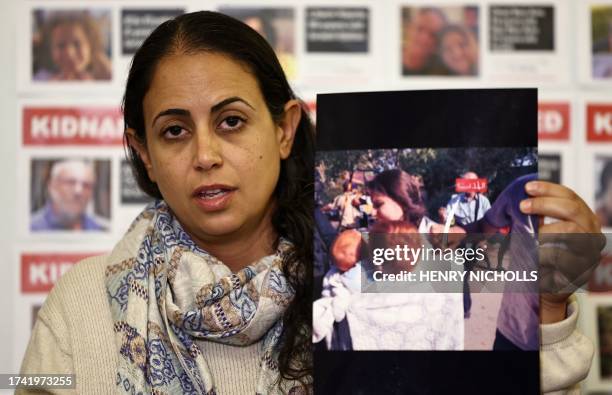 Graphic content / Ofri Bibas Levi holds an image purported to show her sister-in-law Shiri holding her children Ariel and Kfir as they are taken...