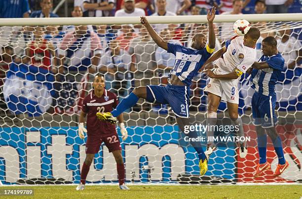 Honduras' goalkeeper Donis Escober watches as teammates Osman Chavez and Juan Carlos Garcia vie for a header with Costa Rica's Alvaro Soborio during...