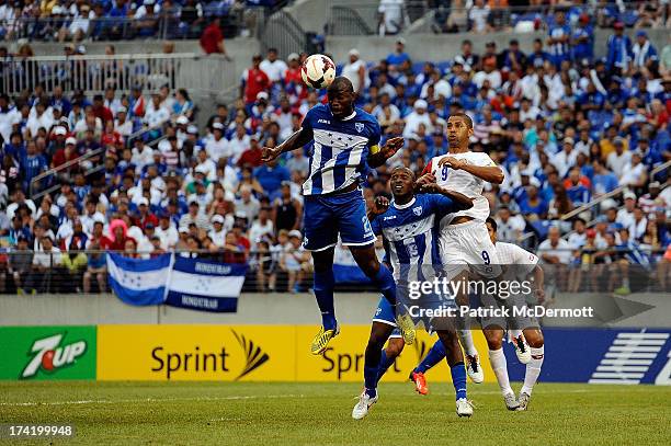 Osman Chavez of Honduras heads the ball as Nery Medina battles with Alvaro Saborio of Costa Rica in the first half during the 2013 CONCACAF Gold Cup...
