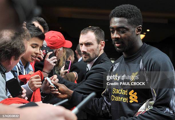 Liverpool defender Kolo Toure signs autographs for fans as the team leaves their hotel for a football training session in Melbourne on July 22, 2013....