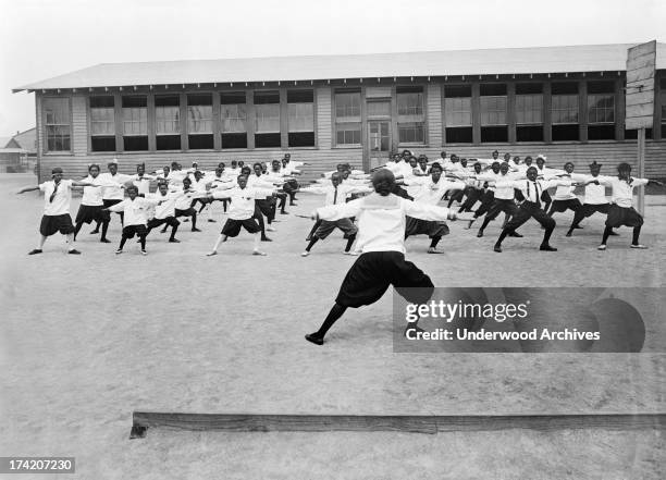 African American children performs exercises during recreation class at Ensley School at the Tennessee Coal, Iron and Railroad Company, Birmingham,...