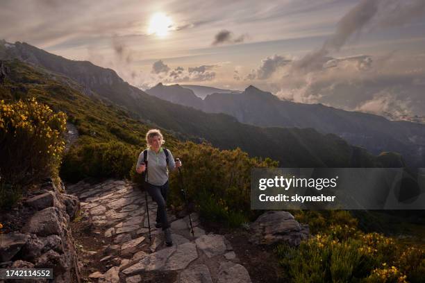 smiling female backpacker hiking on a mountain. - pico ruivo stock pictures, royalty-free photos & images