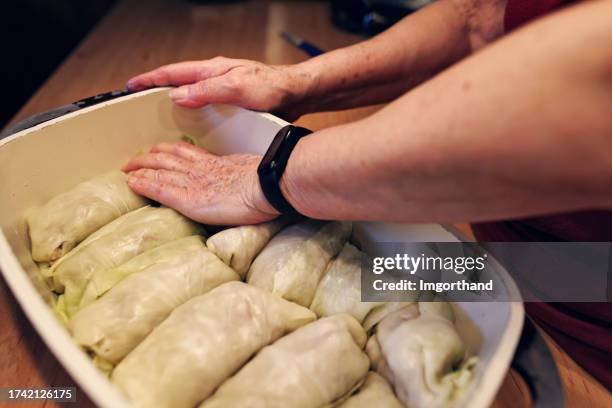 großmutter macht traditionelle kohlrouladen zu weihnachten - kohlroulade stock-fotos und bilder