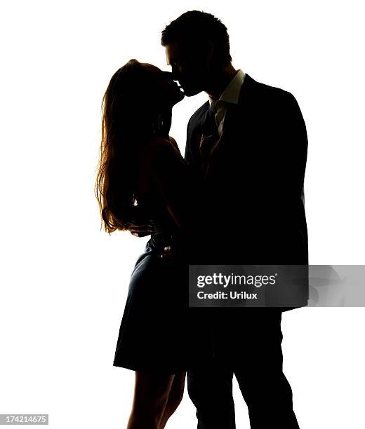 una atractiva pareja compartir una apasionada beso - besar fotografías e imágenes de stock