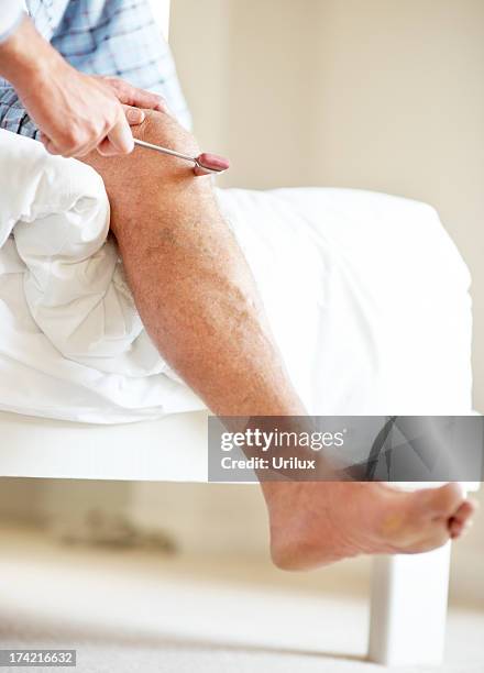 doctor hand checking old man knee using a reflex hammer - reflex hammer stock pictures, royalty-free photos & images