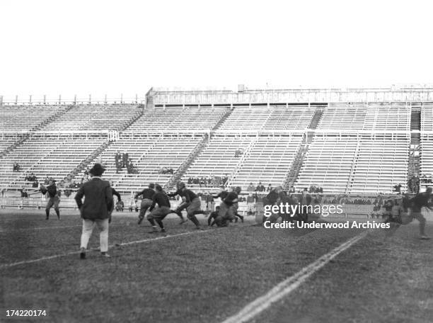 The Yale football team at practice, New Haven, Connecticut, 1913. The quarterback is preparing to throw the ball.