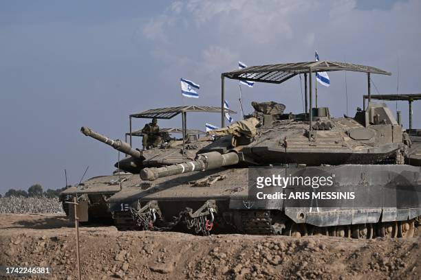 Israeli military armoured vehicles deploy along Israel's border with Gaza on October 24 amid the ongoing battles between Israel and the Palestinian...