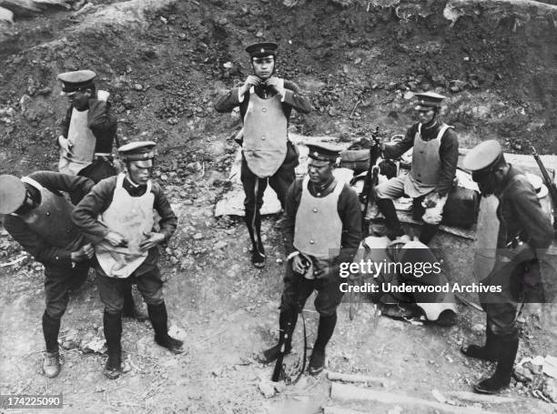 Japanese gendarmes put on bullet proof vests prior to going to the rescue of Chinese shopkeepers who were targeted by Koreans, in Pinvang, Korea,...