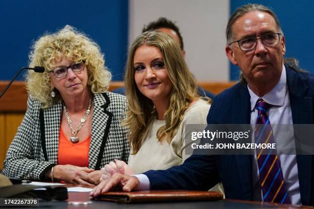 Jenna Ellis reacts with her lawyers after reading a statement pleading guilty to one felony count of aiding and abetting false statements and...