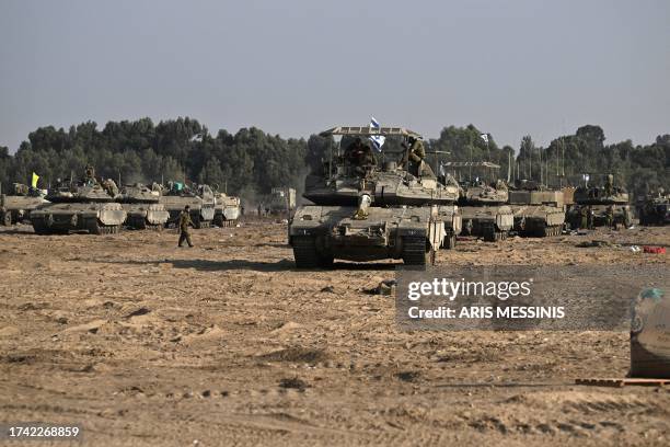 Israeli military armoured vehicles deploy along Israel's border with Gaza on October 24 amid the ongoing battles between Israel and the Palestinian...