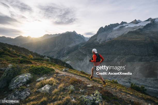 senior male trail runner bounds along mountain trail - road ahead stock pictures, royalty-free photos & images