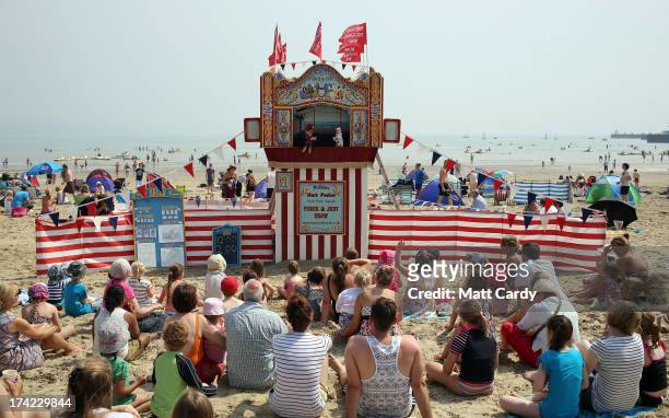 Visitors to Weymouth watch a traditional punch and judy show on the beach on July 22, 2013 in Weymouth, England. According to forecasters the current...