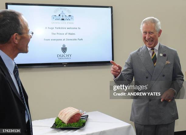 Britain's Prince Charles, Prince of Wales reacts after being given a joint of beef after his tour Dovecote Park in Pontefract, West Yorkshire on July...