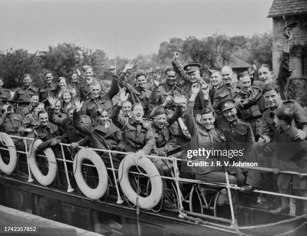 Convalescing wounded British Army soldiers wave to the camera during a riverboat trip down the River Thames on 12th August 1941 at Oxford, England.