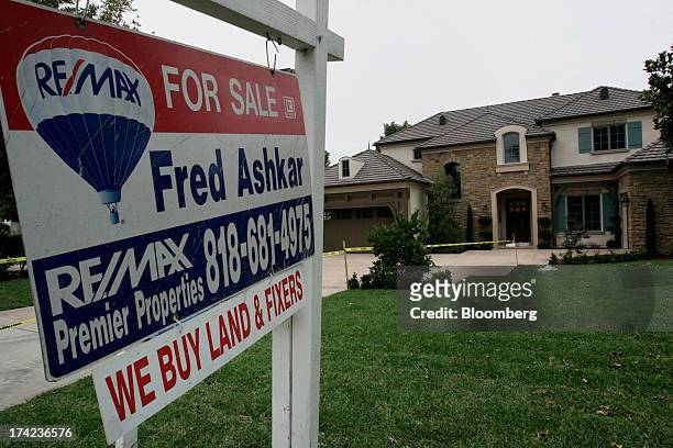 For sale" signs stand outside a home in Arcadia, California, U.S., on Sunday, July 21, 2013. Sales of previously owned houses unexpectedly dropped in...