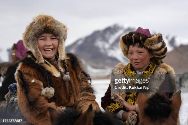 une chasseuse d’aigle d’origine kazakhe et sa famille au festival de l’aigle royal, mongolie - montagnes altaï photos et images de collection