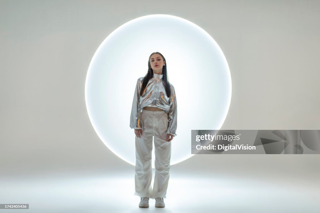 Young woman in front of a circular light shape