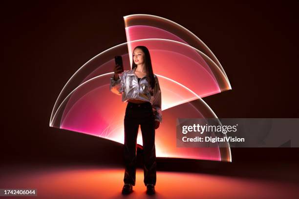 mujer joven usando un teléfono inteligente - realidad aumentada fotografías e imágenes de stock